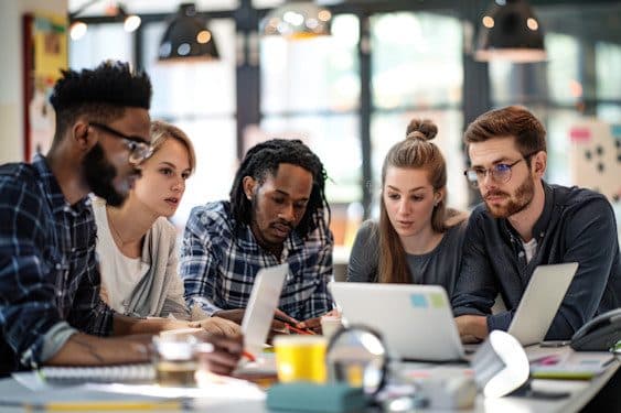Une équipe en réunion de travail autour d’ordinateurs